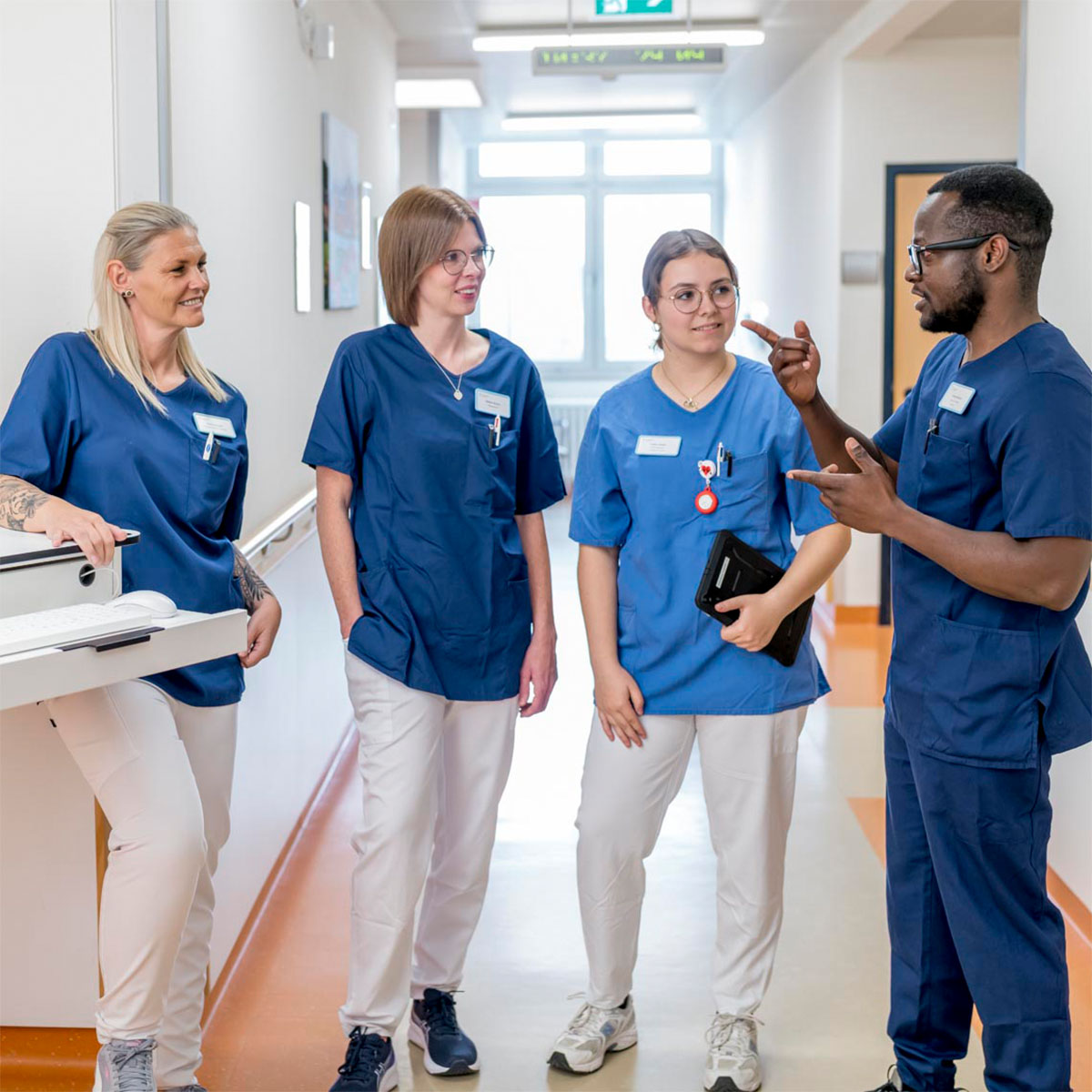 Eine Gruppe Pflegerinnen und ein Arzt stehen auf dem Gang im Krankenhaus Frankenberg und unterhalten sich